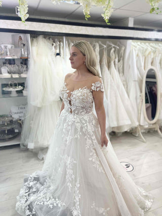 Chic white wedding dress with a sweetheart neckline, strapless design, and lace applique on a dramatic A-line ball gown silhouette, tailored for timeless and sophisticated weddings