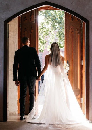 Romantic strapless ivory gown with a fitted bodice, sweetheart neckline, and smooth satin finish, paired with a long veil, perfect for glamorous and elegant bridal celebrations