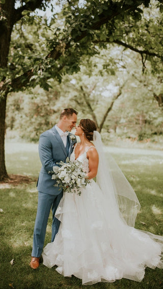 Lace-embellished bridal gown featuring delicate floral detailing, a fitted bodice, and a voluminous skirt, captured during a golden hour ceremony