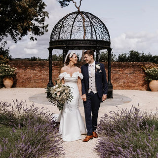 Sophisticated ivory wedding gown crafted from luxurious satin, featuring off-the-shoulder floral details and a dramatic floor-length train, ideal for fairy-tale-inspired bridal occasions