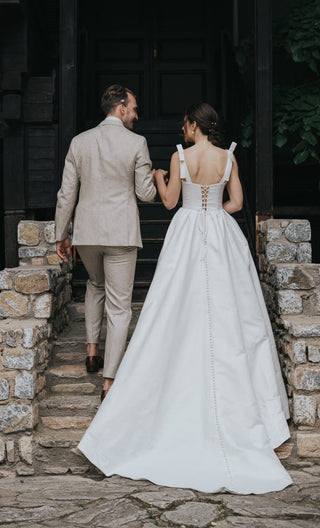 Timeless bridal gown with a sweetheart neckline, adjustable bow shoulder straps, and a flowing full skirt, perfect for romantic outdoor ceremonies