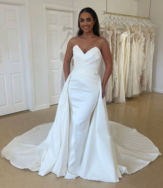 Ivory strapless bridal gown with a sweetheart neckline, fitted bodice, and a dramatic A-line skirt with a sweeping train, perfect for timeless and elegant weddings