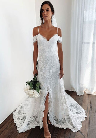 Romantic bridal dress featuring intricate floral lace, cold-shoulder details, and a flowing train, ideal for a bohemian-inspired wedding.