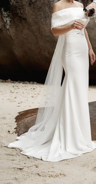 Timeless off-the-shoulder bridal gown with a flattering fit-and-flare design and subtle structural details, offering effortless grace