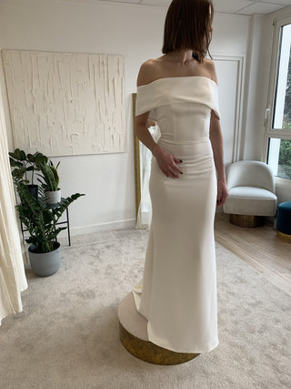 Minimalist off-the-shoulder ivory wedding gown with a fitted silhouette, perfect for a modern bride seeking understated elegance