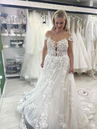 Sophisticated white strapless bridal gown with a sweetheart neckline, intricate lace detailing, and an A-line floor-length tulle silhouette, designed for magical and timeless weddings