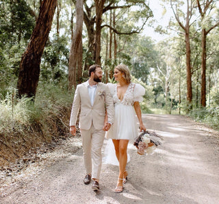 Delicate tulle wedding dress featuring a plunging neckline, dotted puff sleeves, and soft floral embellishments, perfect for whimsical summer weddings or forest-themed celebrations