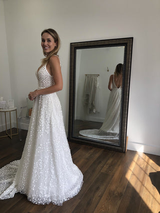 Sophisticated champagne mermaid gown adorned with 3D floral lace detailing, off-the-shoulder neckline, sweetheart bodice, and a fit-to-flare tulle silhouette, perfect for timeless weddings