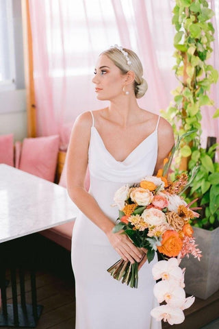 Sophisticated wedding dress featuring a graceful draped neckline, slim spaghetti straps, and a chic mermaid-inspired fit, perfect for romantic ceremonies