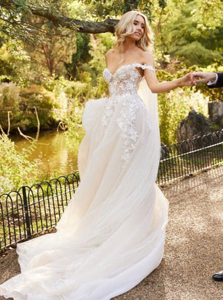 Elegant ivory wedding dress featuring intricate floral lace embroidery, off-the-shoulder sweetheart neckline, and tulle ball gown silhouette, ideal for fairy-tale weddings and glamorous occasions