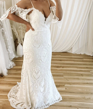 Ivory A-line wedding gown with intricate 3D floral lace applique, sweetheart neckline, sheer long puff sleeves, and a floor-length tulle design, perfect for romantic and elegant bridal occasions