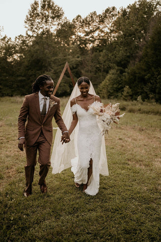 Modern lace wedding dress with a thigh-high slit, off-the-shoulder sleeves, and a sophisticated train for a contemporary yet timeless bridal look.