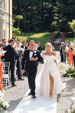 Timeless white wedding dress designed with a grand, voluminous train and minimalist elegance, suited for romantic and stately venues