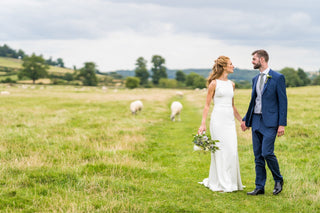 Elegant sleeveless bridal gown in ivory with a high neckline, figure-flattering fit, and a flowing train, perfect for understated and stylish wedding celebrations