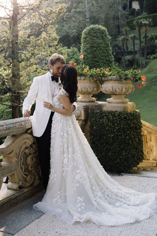 Elegant ivory wedding dress, featuring intricate 3D floral embroidery, cap sleeves, deep V-neckline, and sexy low back, designed for fairytale-inspired bridal looks