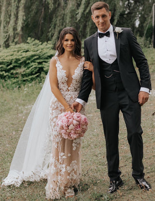 Sophisticated ivory tulle wedding dress with intricate lace embroidery, deep V-plunge neckline, thin spaghetti straps, and a flowing A-line silhouette, ideal for magical and timeless bridal occasions