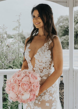 Elegant ivory wedding dress featuring intricate floral embroidery, deep V-plunge neckline, delicate spaghetti straps, and a flowy A-line tulle design, ideal for classic and romantic bridal styles