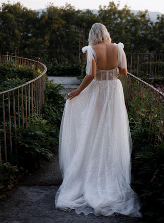 Elegant bridal gown featuring a structured bustier, sparkling embellishments, and soft tulle skirt for a glamorous wedding style