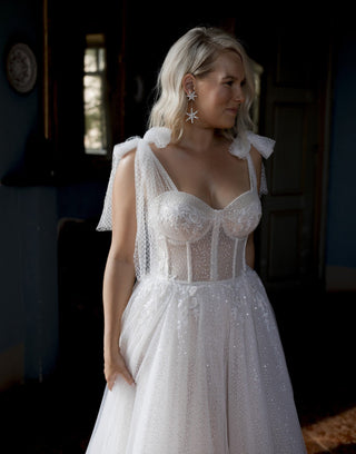 Romantic wedding dress with a sheer corset bodice, delicate lace detailing, and shimmering sequins, ideal for a fairytale bridal look,