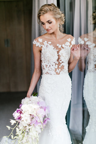 Sophisticated ivory mermaid bridal dress with intricate floral lace, strapless sweetheart neckline, illusion off-the-shoulder short sleeves, and fit-and-flare design, perfect for modern and elegant weddings