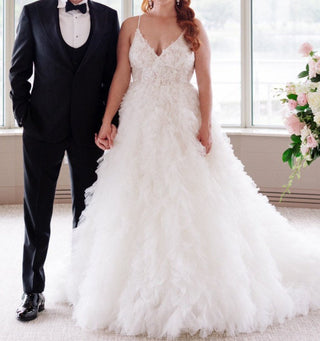 legant bridal gown featuring a V-neck lace bodice and voluminous tiered tulle skirt, perfect for a luxurious wedding look