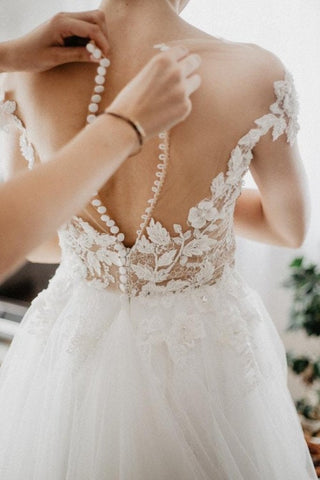 Chic lace wedding dress with a V-neckline, floral appliqués cascading over the bodice, and a dreamy tulle skirt, designed for brides seeking an elegant yet modern style