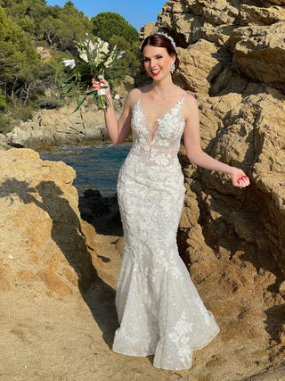 Glamorous sequined bridal gown with floral appliqués, a fitted bodice with sheer details, and a flared mermaid skirt, perfect for brides seeking a bold and timeless look






