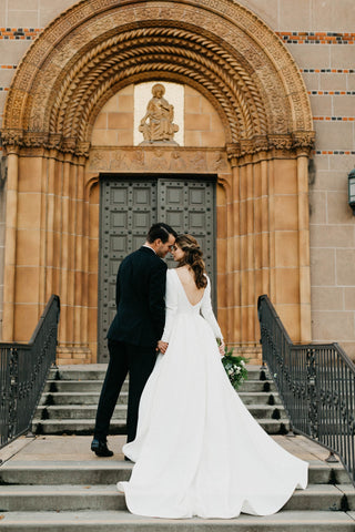 A blend of sophisticated design and romantic elements, this dress is perfect for brides who appreciate timeless fashion. The structured puffed sleeves, sleek satin fabric, and graceful A-line silhouette create a formal yet romantic appearance. Whether you’re planning a classic church wedding or a chic modern ceremony, this dress is sure to leave a lasting impression.