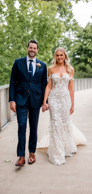 Romantic ivory fit-and-flare bridal gown, adorned with floral lace detailing, sweetheart neckline, and decorated thin straps, perfect for contemporary fairy-tale-inspired weddings