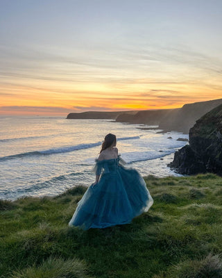 Ethereal steel-blue gown with voluminous layers and a flattering strapless design, perfect for fashionable soirées