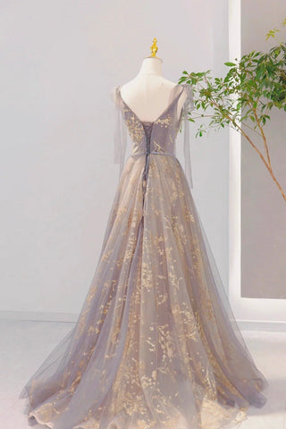 Delicate tulle overlays adorned with intricate gold floral designs, creating a dreamy silhouette