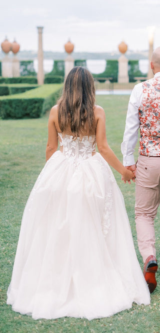 Romantic ball gown with a structured bodice, floral lace embellishments, and a tulle skirt, perfect for a fairy-tale wedding