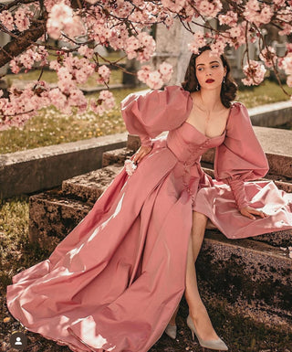 A striking dusty rose gown with a fitted bodice featuring a sweetheart neckline and corset-style details