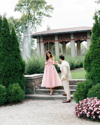 Chic pink A-line gown with floral accents, a soft tulle overlay, and a flattering strapless neckline, perfect for creating a feminine and romantic statement