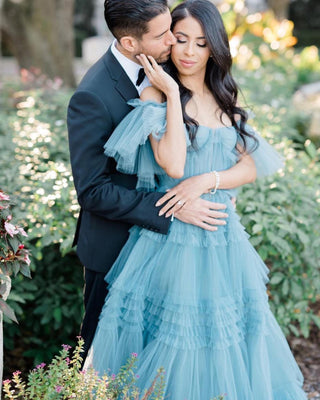 Chic dusty blue ruffled gown crafted from layers of soft tulle, offering a statement look for red-carpet events