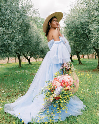 Elegant flowing blue gown with sheer tulle sleeves and a thigh-high slit, combining sophistication and whimsical charm for countryside or rustic weddings