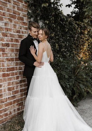 Elegant tulle wedding gown with a flattering A-line silhouette, soft plunging neckline, and tiered skirt, perfect for indoor or outdoor weddings with a romantic atmosphere