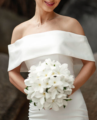 Timeless off-the-shoulder bridal gown with a flattering fit-and-flare design and subtle structural details, offering effortless grace