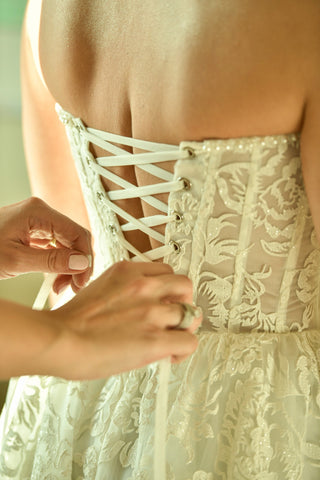 Stunning wedding dress with a corset-style bodice and detailed floral lace, a beautiful choice for brides who appreciate traditional elegance.