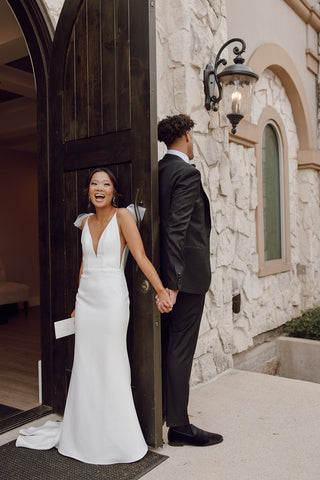 Modern yet romantic bridal ensemble showcasing clean lines, airy tulle bows, and a stunning arrangement of white roses