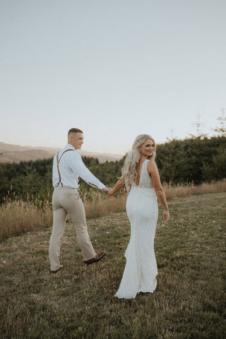 Timeless bridal style in a sleeveless, deep neckline lace gown, perfect for a chic and sophisticated wedding