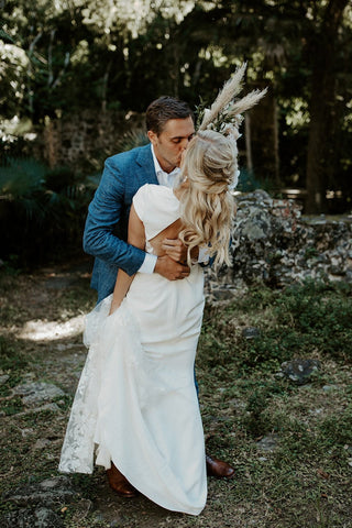 Elegant ivory bridal gown featuring cap sleeves, a flattering A-line silhouette, and a high-low hemline, ideal for casual and nature-inspired weddings