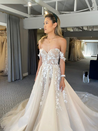 Romantic ivory tulle ball gown, adorned with 3D floral lace detailing, sweetheart neckline, and off-the-shoulder style, perfect for a magical and elegant bridal celebration