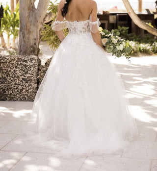 Delicate wedding dress featuring sheer lace details, floral appliqués, and an ethereal ballgown silhouette