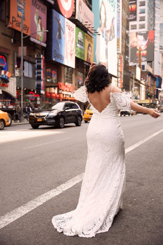 Sophisticated ivory bridal gown with intricate floral lace applique, sweetheart neckline, long puff sleeves, and a floor-length A-line silhouette, ideal for elegant wedding celebrations