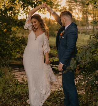 Chic ivory wedding gown with floral lace detailing, sweetheart neckline, sheer puff sleeves, and a flowy A-line floor-length design, tailored for sophisticated bridal styles