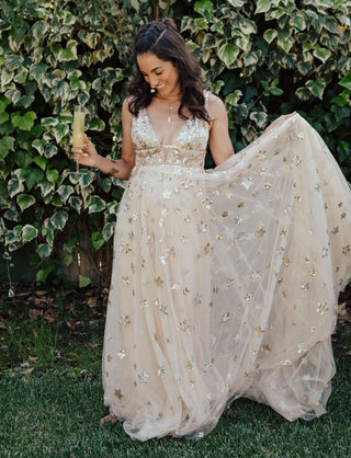 Elegant cream beige gown adorned with glitter star print and celestial sequins, featuring a deep V-neckline and A-line silhouette, ideal for weddings, proms, and special events