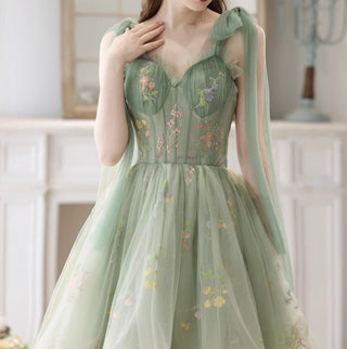 High-low sage green dress featuring a sweetheart neckline, flowing layers, and intricate flower detailing, ideal for whimsical or nature-inspired events