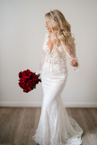 Ivory lace wedding gown with intricate floral embroidery, deep V-neckline, sleeveless design, and A-line silhouette, perfect for romantic and traditional bridal looks