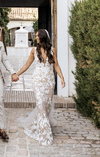 Ivory A-line bridal gown with 3D floral lace applique, deep V-neckline, thin spaghetti straps, and a flowing floor-length tulle silhouette, perfect for modern and elegant weddings